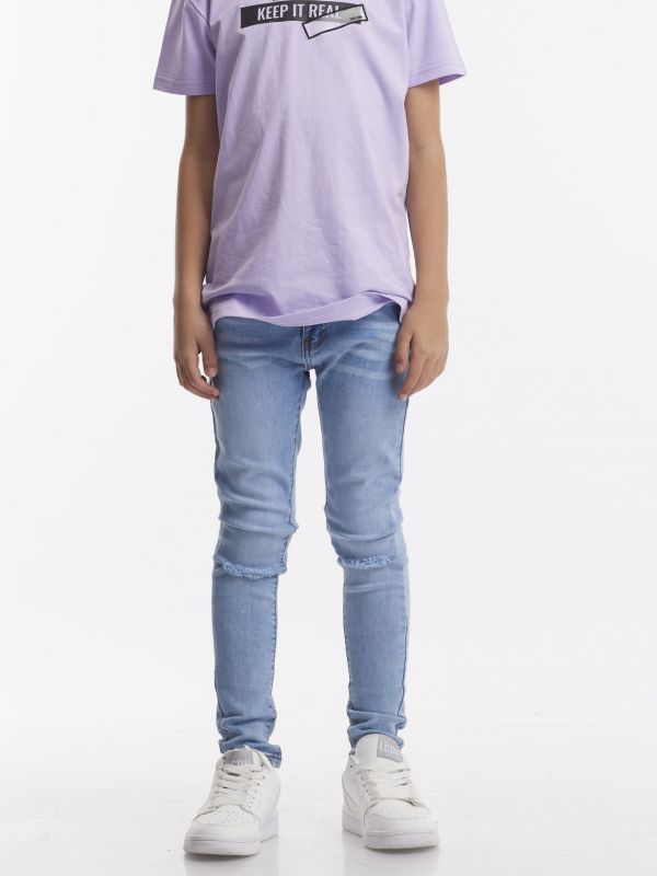 ג’ינס בהיר עם קרעים בברכיים